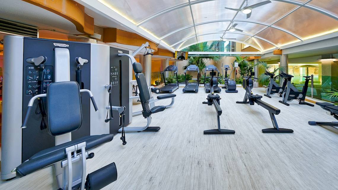Fitnessstudio im Bull Dorado Beach & Spa mit verschiedenen Trainingsgeräten und einer großen Glasdecke.