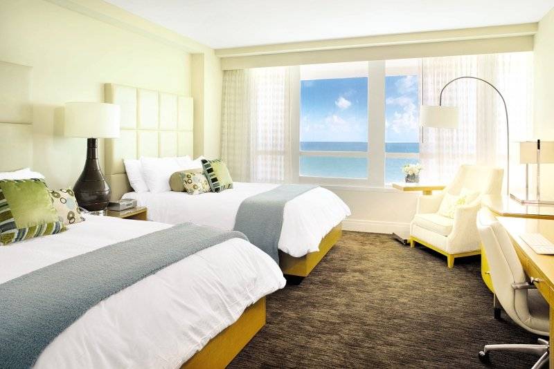 Zwei Betten in einem Hotelzimmer im Fontainebleau Miami Beach mit Meerblick.