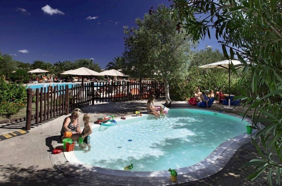 Familie mit Kindern am Kinderbecken im Resort Cala Di Falco.