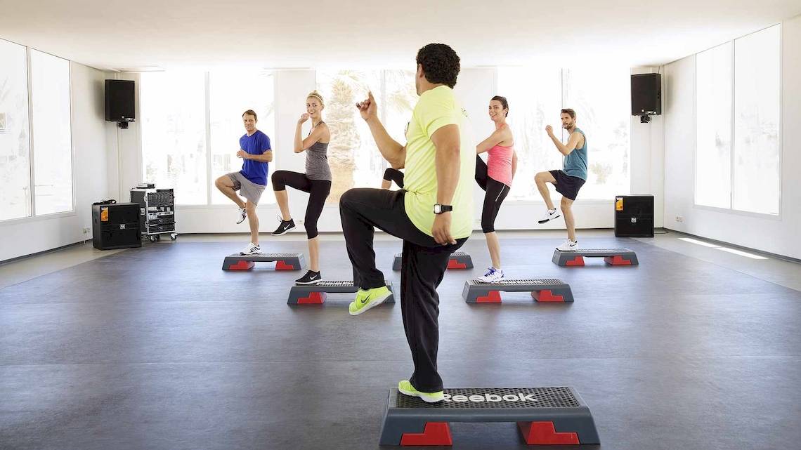 Fitnesskurs im Robinson Djerba Bahiya Hotel mit Teilnehmern auf Stepper-Plattformen.