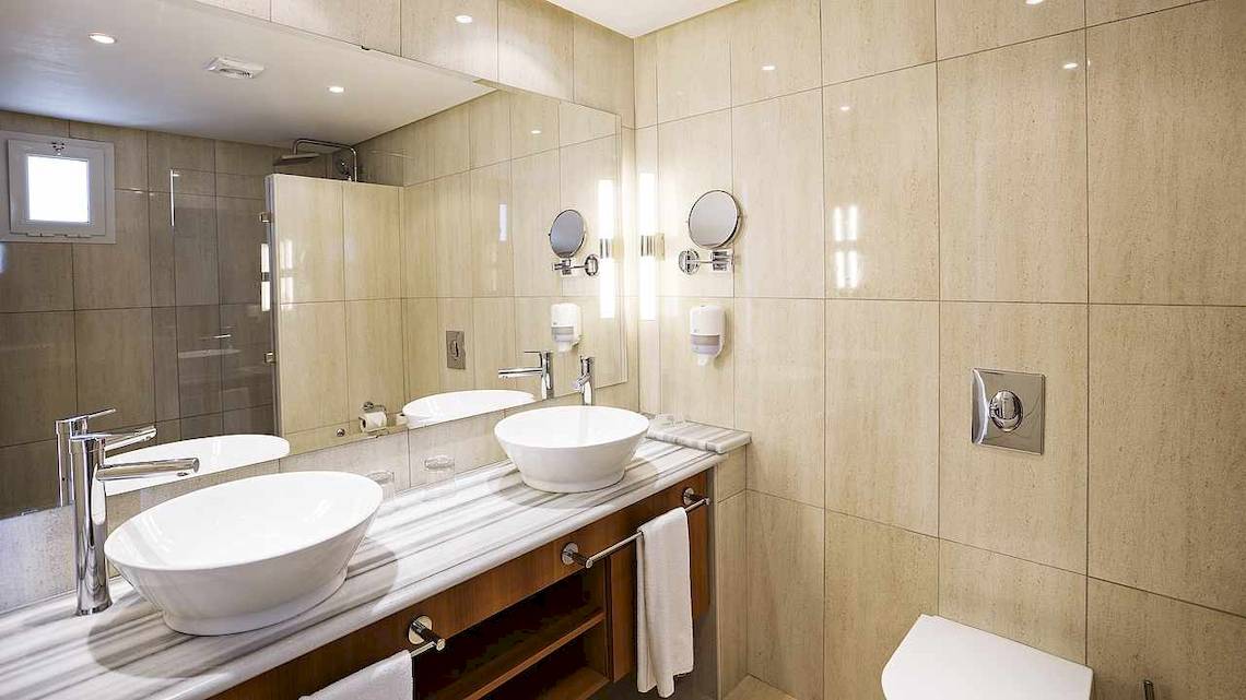 Das Badezimmer des Robinson Djerba Bahiya Hotels mit zwei Waschbecken, Spiegeln und einem Toilettensitz.