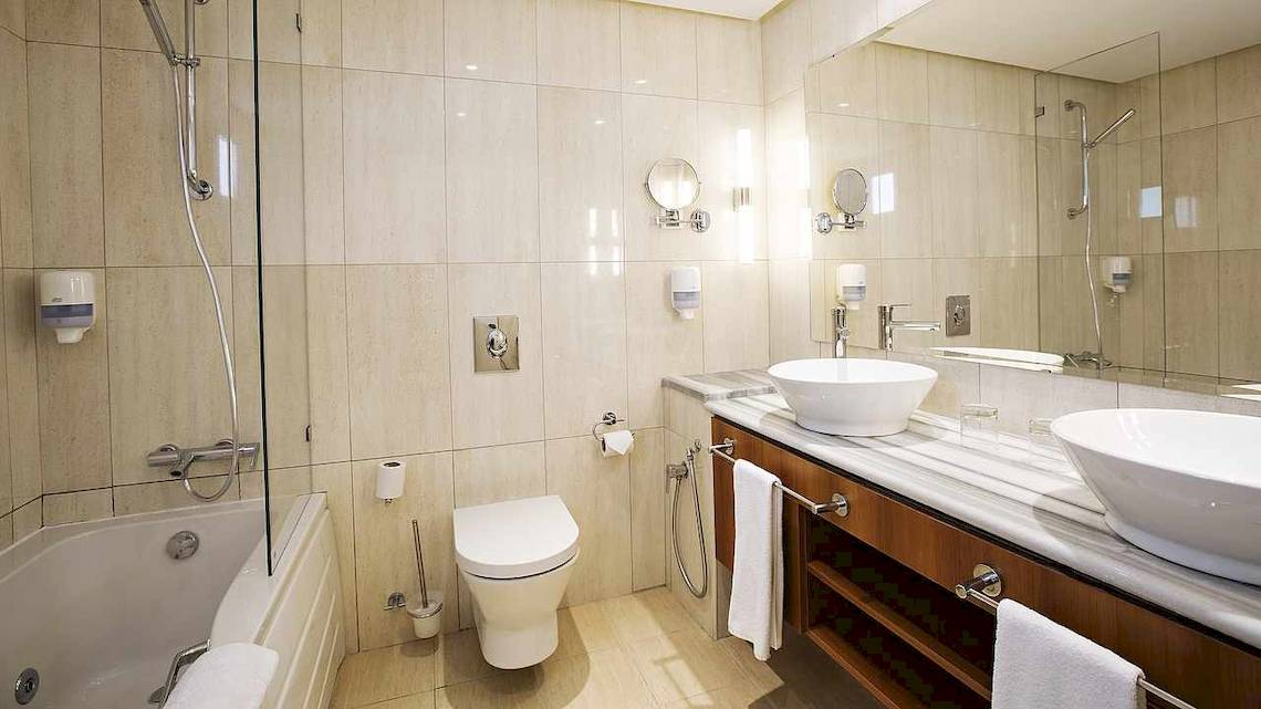 Badezimmer im Robinson Djerba Bahiya Hotel mit Badewanne, Toilette, Waschbecken und Spiegel.