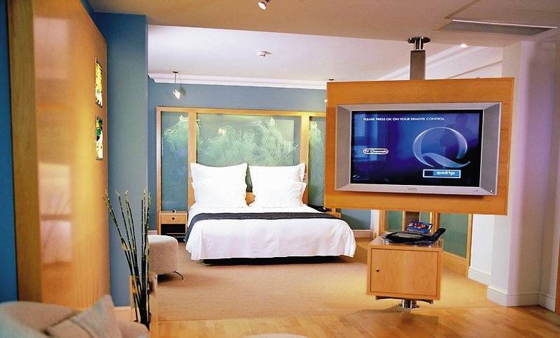 Ein Hotelzimmer im Cumberland mit einem Bett, Fernseher, und einem Tisch