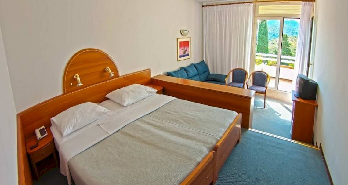 Hotelzimmer im Osmine Slano mit zwei Betten, einem Fernseher und einem Balkon.
