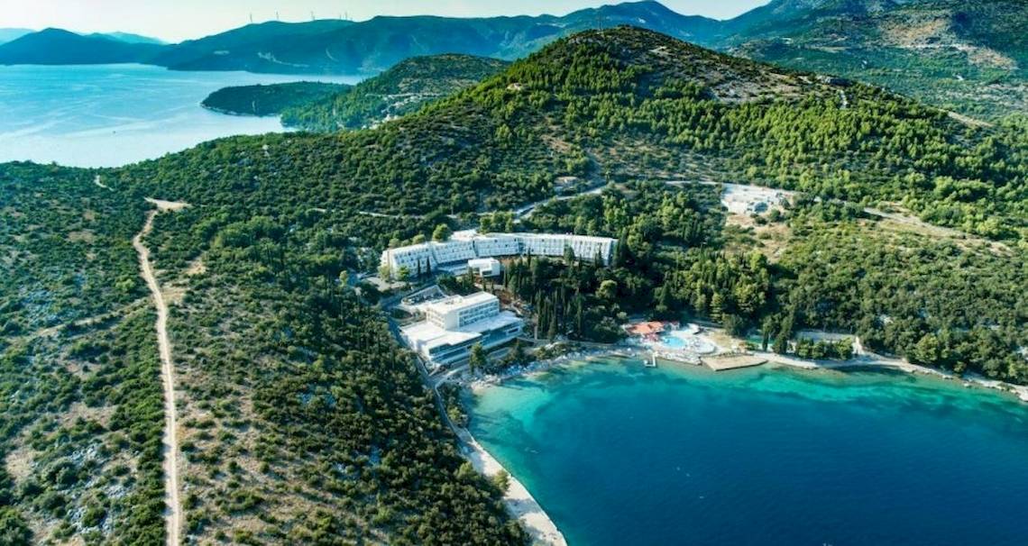 Luftaufnahme des Osmine Slano Hotels umgeben von grünen Hügeln und blauem Meer.