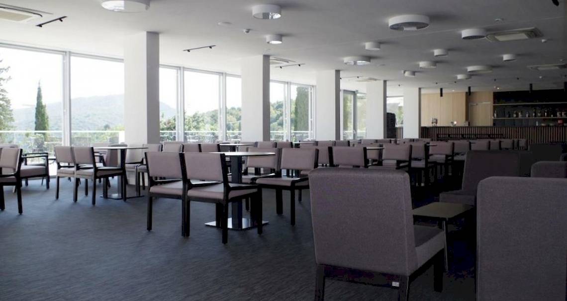 Innenansicht des Restaurants im Osmine Slano Hotel mit runden Tischen und Stühlen.