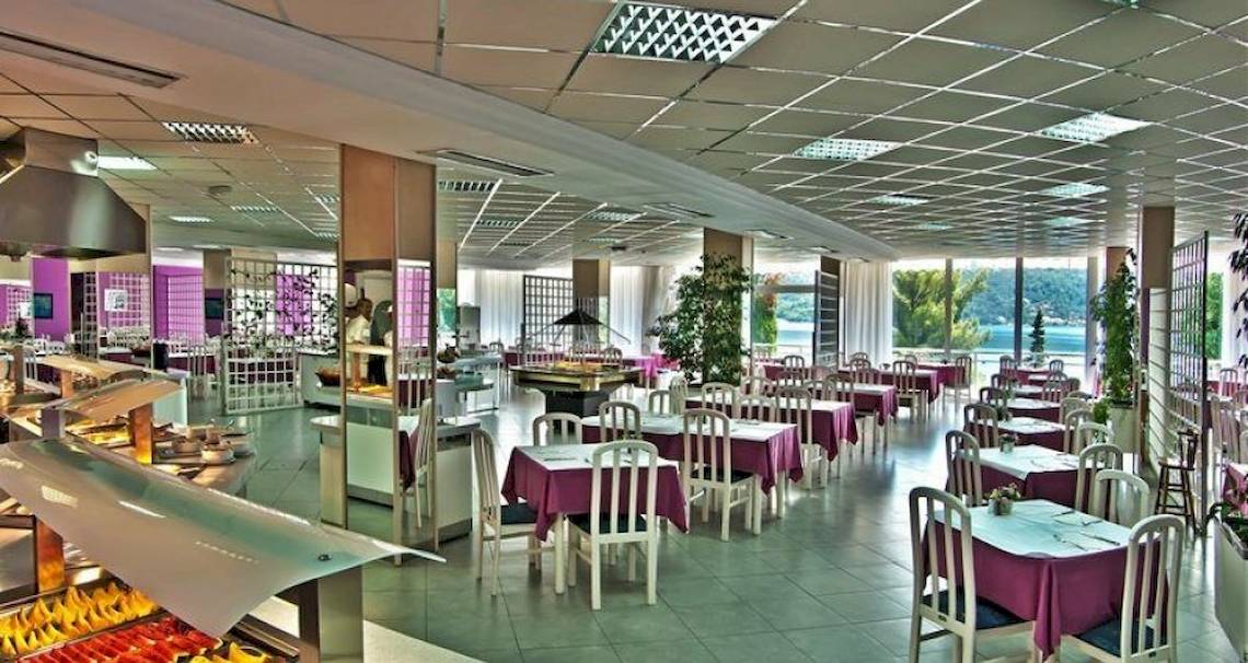 Innenansicht des Restaurants im Osmine Slano Hotel mit runden Tischen, Stühlen und Buffet.