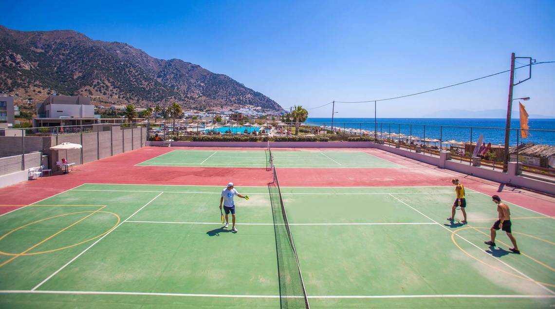 Tennisplätze am Strand des Akti Palace Hotels mit Spielern und Blick auf das Meer.