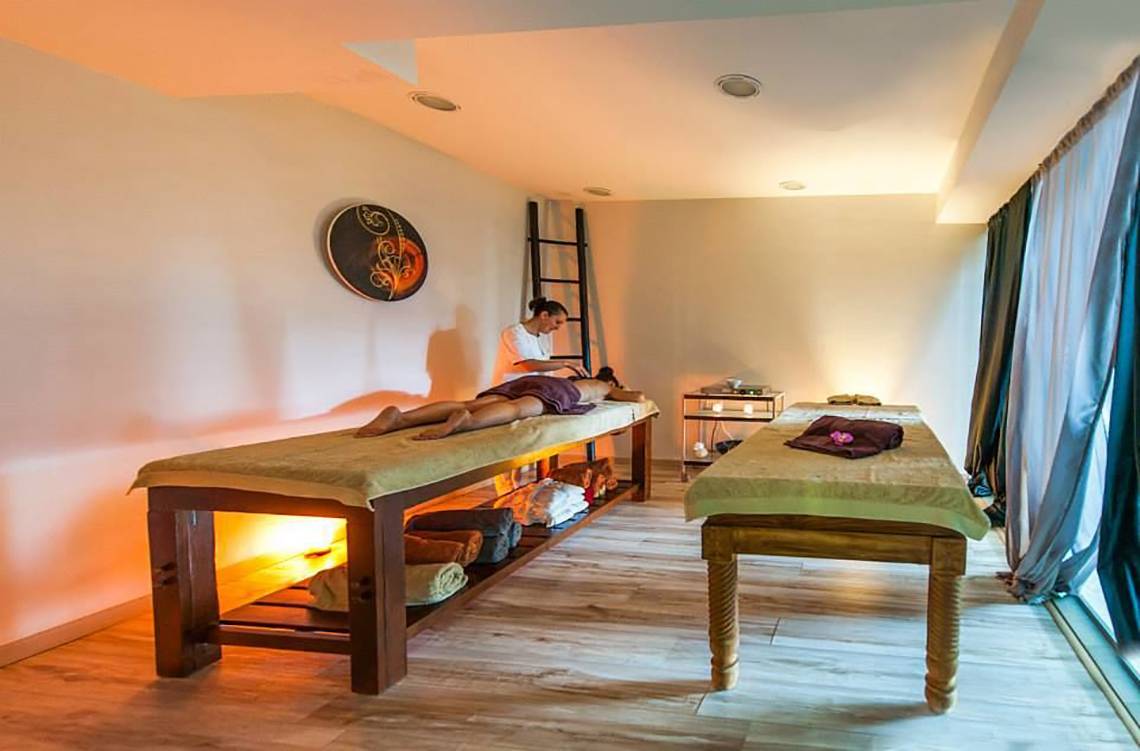 Spa-Behandlung im Akti Palace Hotel mit einem Mann, der eine Massage erhält.