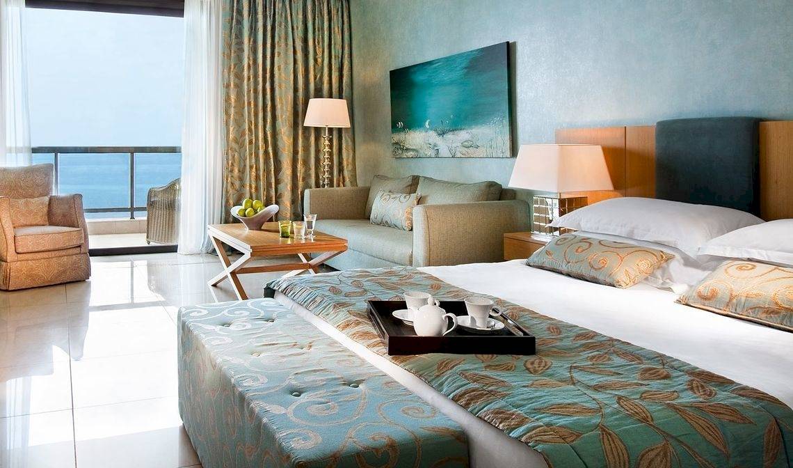 Hotelzimmer im Ikos Oceania mit Blick auf das Meer, Möbel und Dekor.