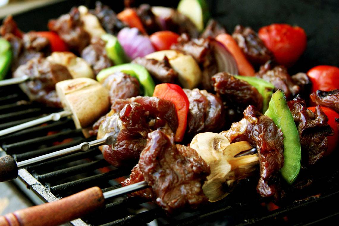 Gegrillte Fleisch- und Gemüsespieße auf einem Grillrost