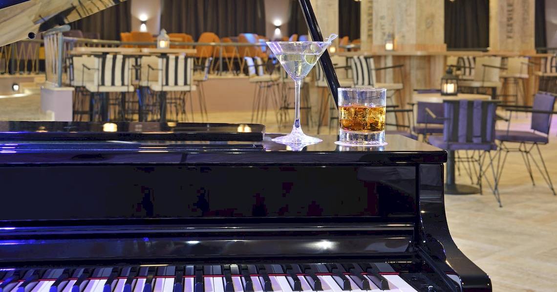 Ein Klavier mit einem Glas Martini und einem Glas Whiskey im Sol Luna Bay Hotel.