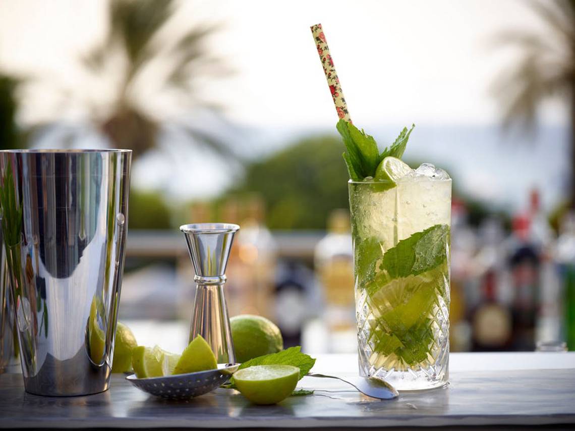 Cocktail auf einem Tisch im Rhodes Bay Hotel & Spa mit Mojito-Glas, Minzblättern und Zitronenscheiben.