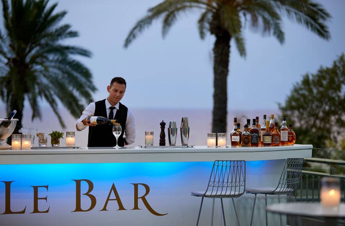 Barkeeper des Rhodes Bay Hotel & Spa serviert ein Getränk an der Bar.