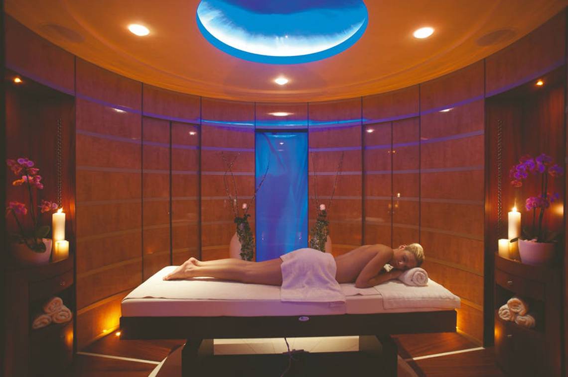 Behandlungsraum im Rhodes Bay Hotel & Spa mit einer Frau auf einer Massageliege.
