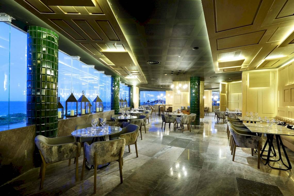 Innenansicht des Restaurants im TRS Coral Hotel mit großen Fenstern und Meerblick.