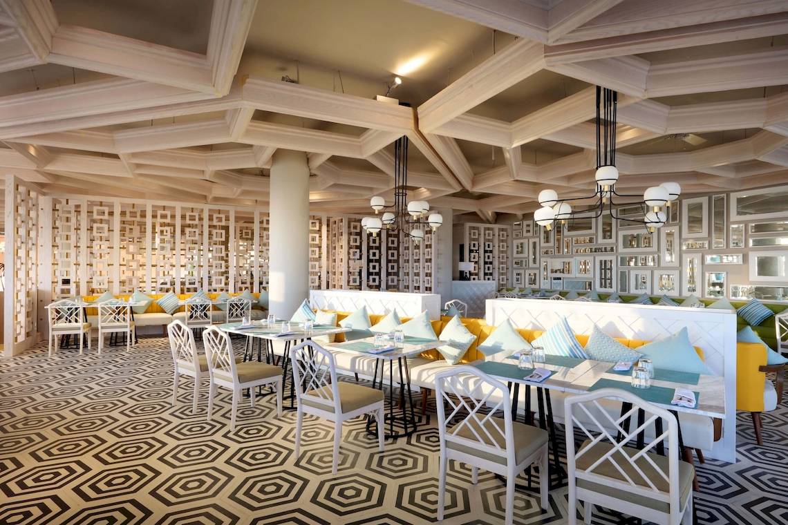 Innenbereich des TRS Coral Hotels mit geometrischem Musterboden und weißen Möbeln.