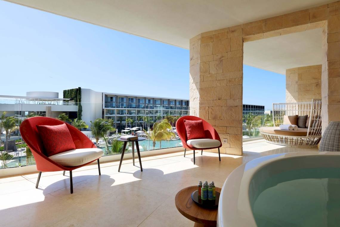 Balkonbereich des TRS Coral Hotels mit zwei roten Sesseln, einer Badewanne und Blick auf das Meer.