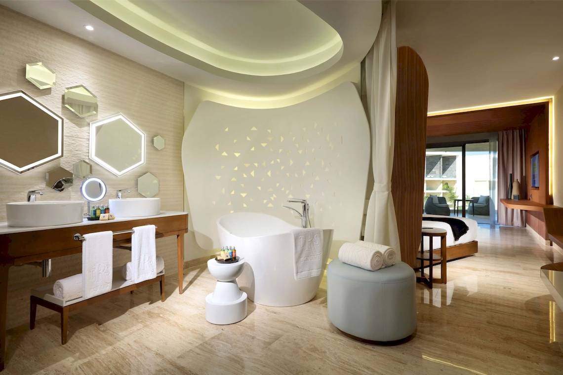 Ein modernes Badezimmer mit einer Badewanne, zwei Waschbecken und einer Dusche im TRS Coral Hotel.