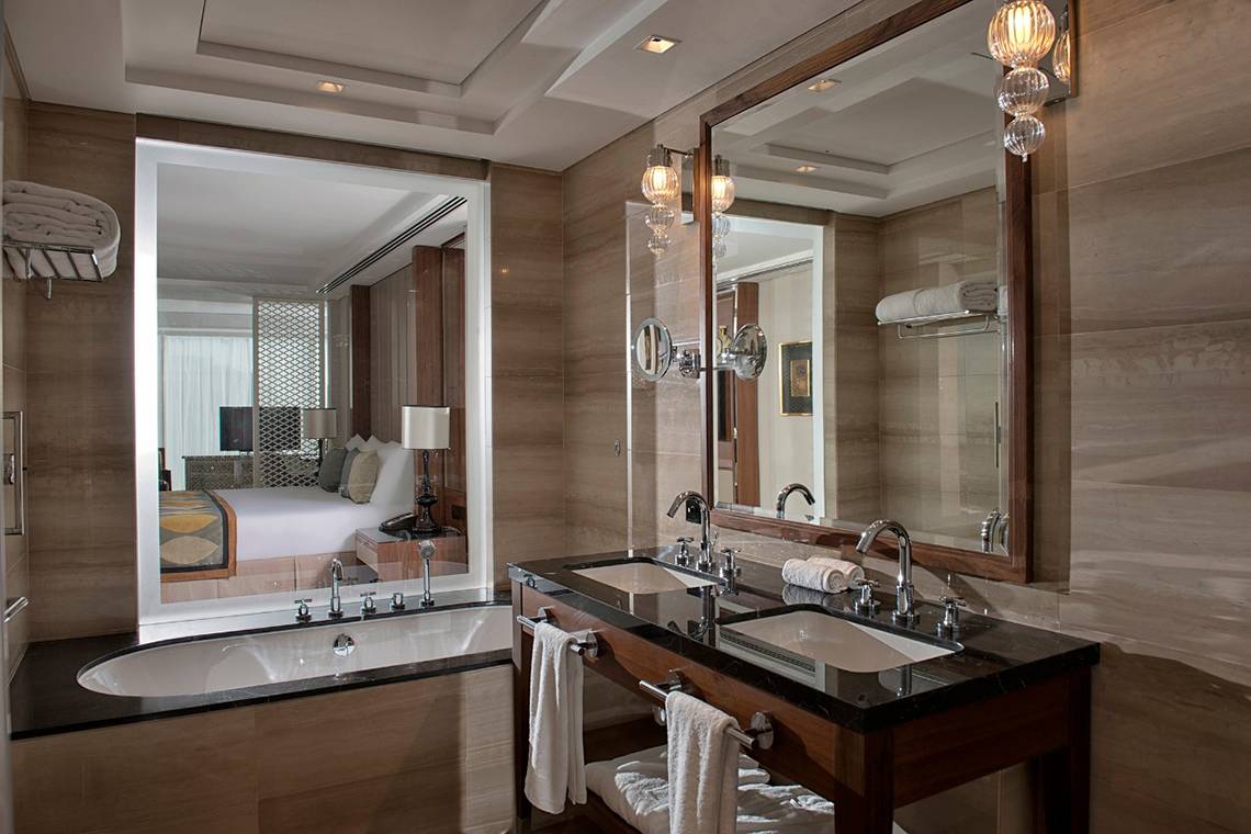 Luxuriöses Badezimmer im Taj Dubai Hotel mit Badewanne, zwei Waschbecken und Spiegel.