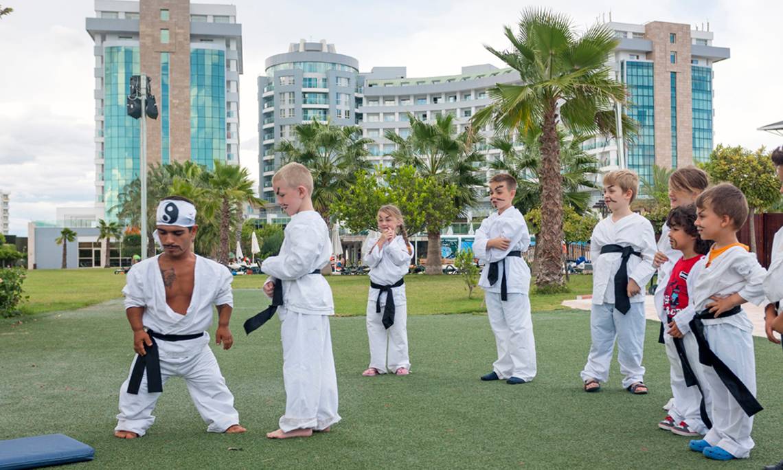 Kinder nehmen an einem Kung-Fu-Kurs im Freien vor dem Sherwood Exclusive Lara Hotel teil.