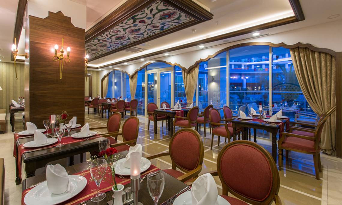 Innenbereich des Sherwood Exclusive Lara Hotel Restaurants mit gedeckten Tischen und Stühlen.