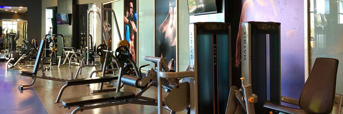 Fitnessstudio im Sherwood Exclusive Lara Hotel mit verschiedenen Trainingsgeräten und Monitoren.
