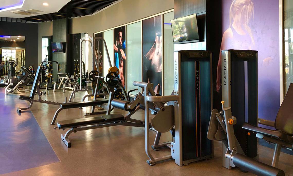 Fitnesscenter-Innenansicht im Sherwood Exclusive Lara Hotel mit verschiedenen Geräten und Plakaten.