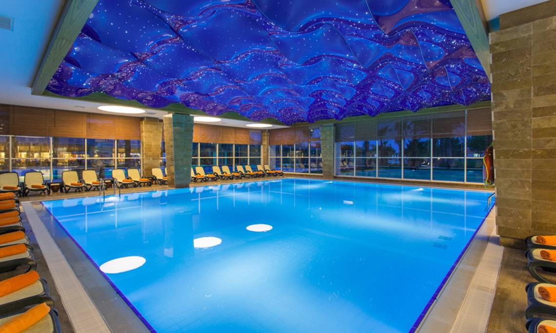 Innenpool des Sherwood Exclusive Lara Hotels mit Sternenhimmeldecke und Sonnenliegen