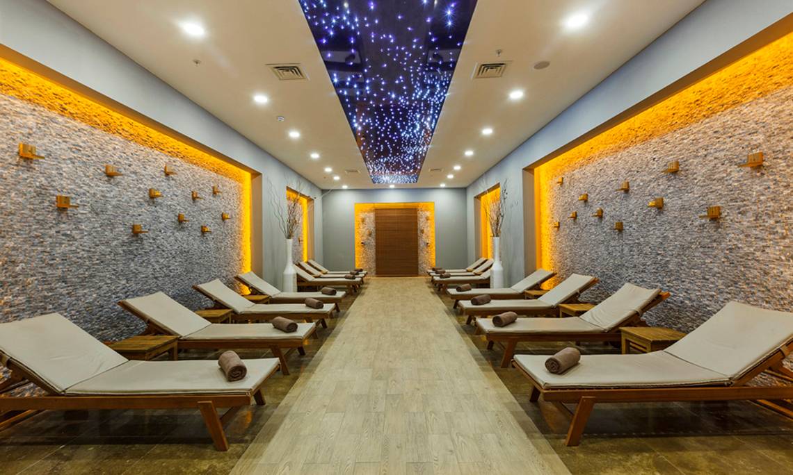 Relaxationsraum im Sherwood Exclusive Lara Hotel mit gepolsterten Liegen und Steinwänden.