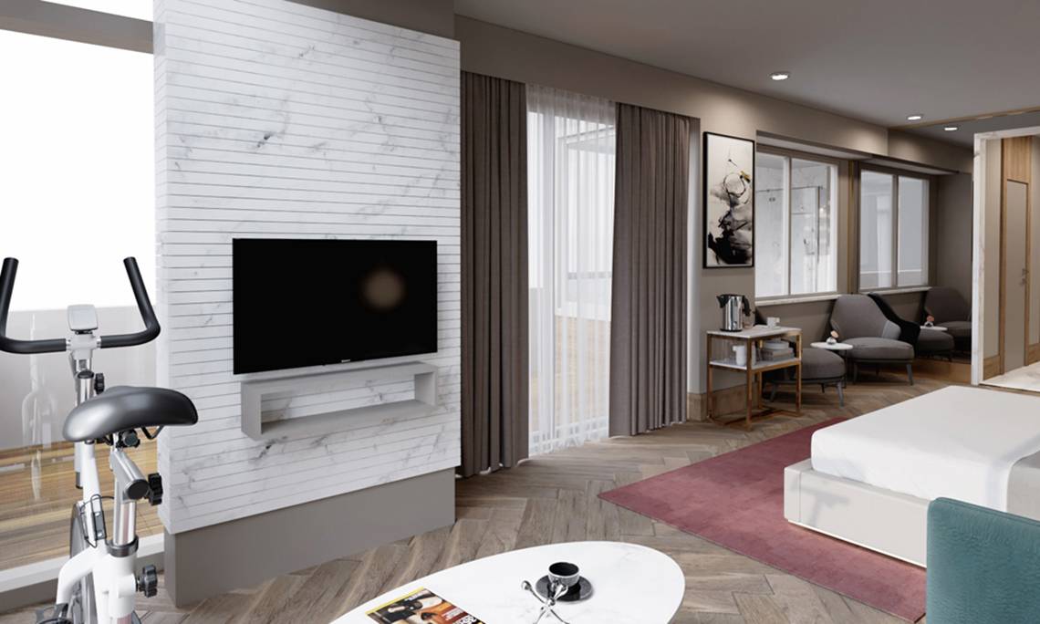 Innenansicht eines Zimmers im Sherwood Exclusive Lara Hotel mit Fernseher, Fitnessgeräten und Möbeln.