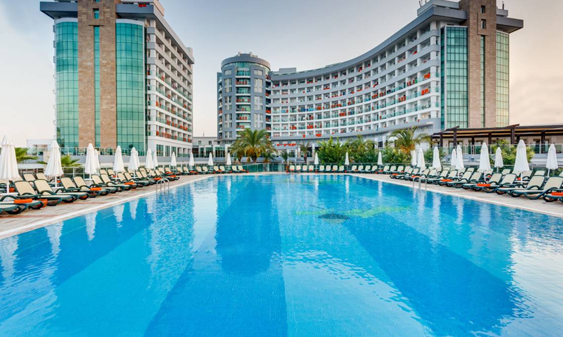 Außenpool des Sherwood Exclusive Lara Hotels mit vielen Liegen und Sonnenschirmen.