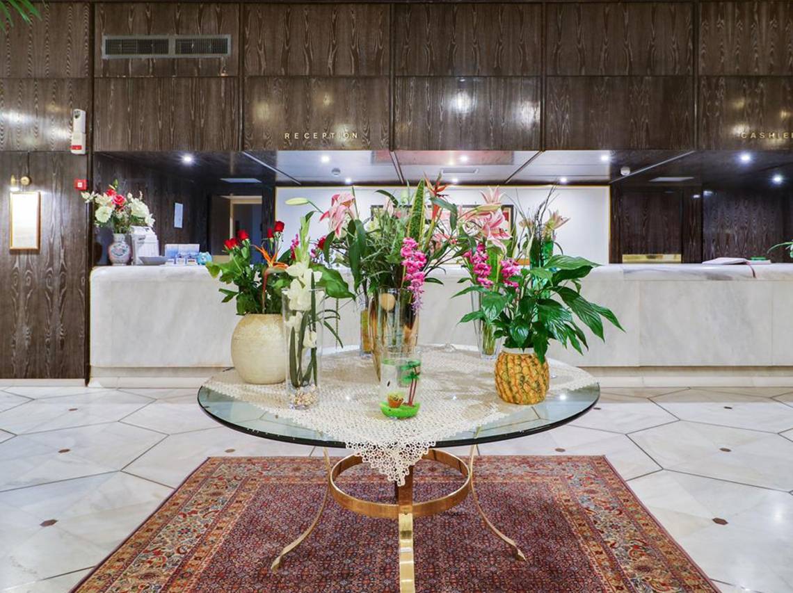 Empfangsbereich des Creta Star Hotels mit runden Tisch und Blumenarrangements.
