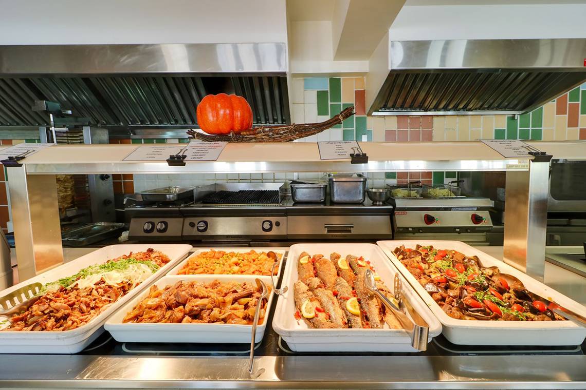 Buffet mit verschiedenen Gerichten im Hotel Creta Star, darunter gebratenes Fleisch, Gemüse und Fisch.