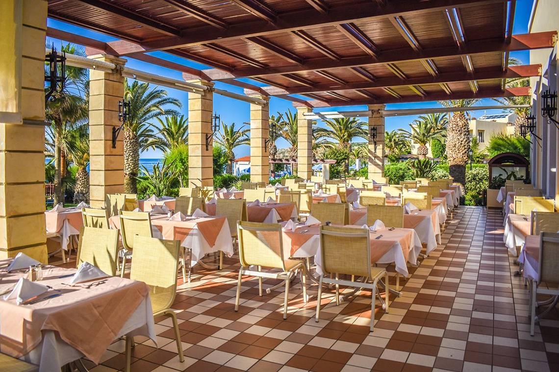 Terrasse des Creta Star Hotels mit braun-weiß gefliestem Boden und vielen freien Tischen.