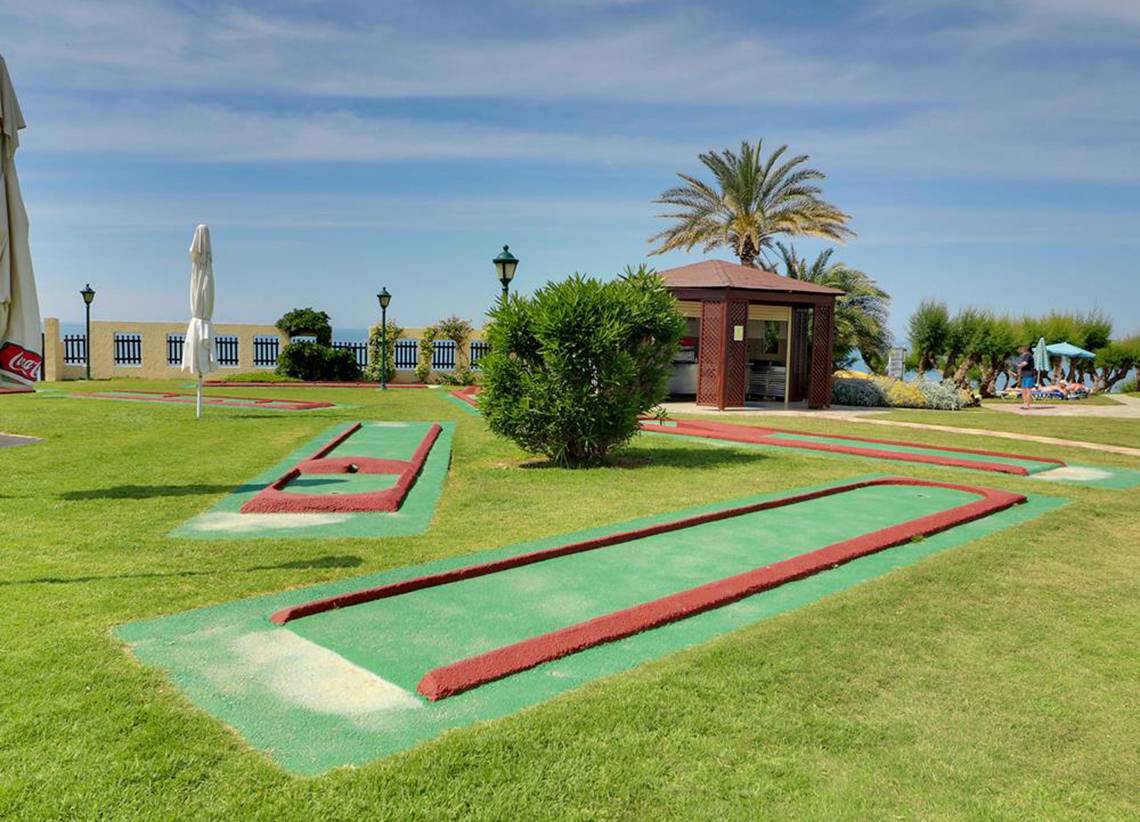 Minigolf-Anlage im Freien neben dem Creta Star Hotel mit blauem Himmel und Palmen.