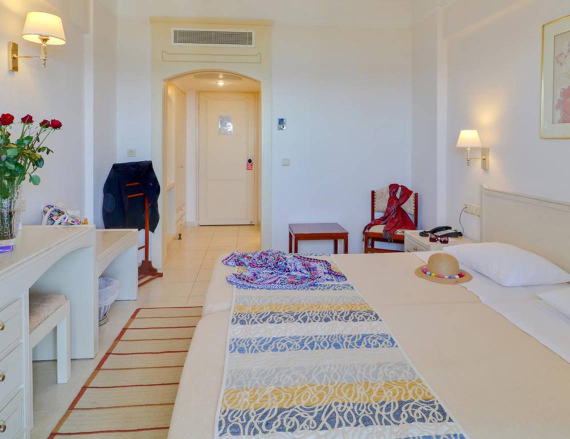 Hotelzimmer im Creta Star mit zwei Betten, Dekor und Möbeln.