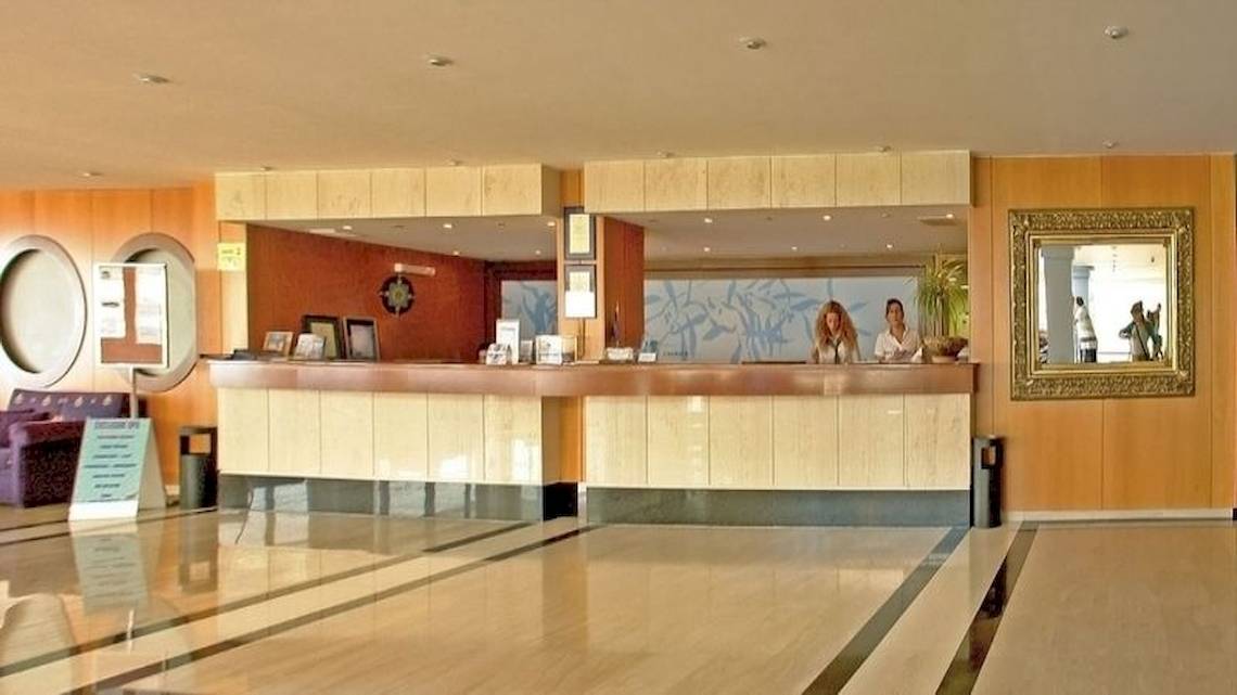 Empfangsbereich des Royal & Imperial Belvedere Hotels mit zwei Mitarbeitern hinter der Rezeptionstheke.
