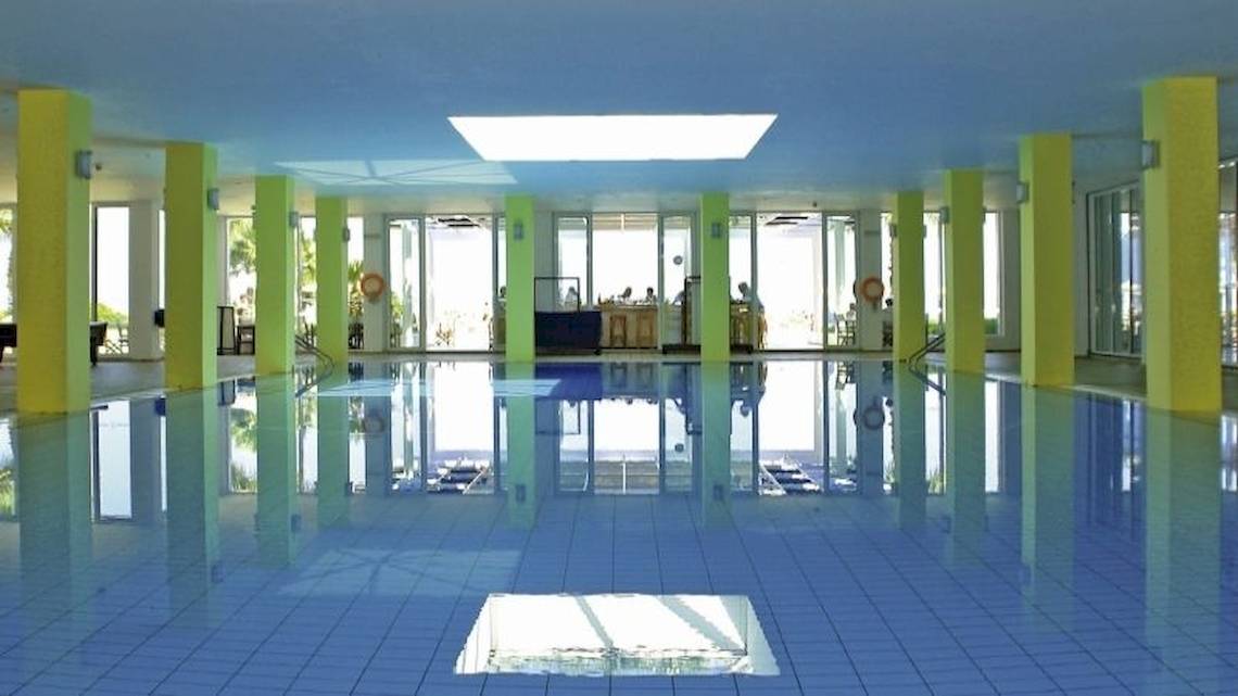 Innenpool des Royal & Imperial Belvedere Hotels mit blauen Fliesen und gelben Säulen.