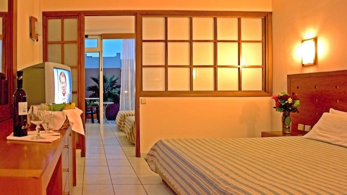 Ein Zimmer im Royal & Imperial Belvedere Hotel mit Bett, Fernseher, Tisch und Balkonzugang.