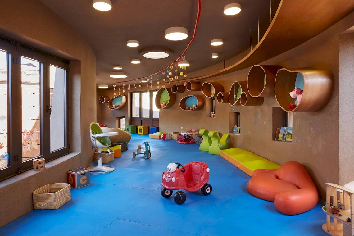 Kinderspielbereich im Westin Resort, Costa Navarino mit bunten Spielzeugautos und Möbeln.