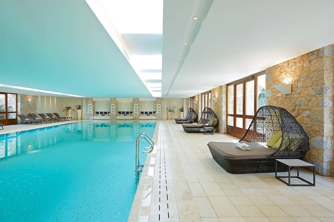 Innenpool im Westin Resort, Costa Navarino mit Liegestühlen und Loungemöbeln.