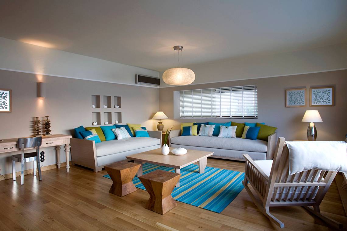 Wohnzimmer im Domes of Elounda, Autograph Collection mit heller Holzboden und modernen Möbeln.