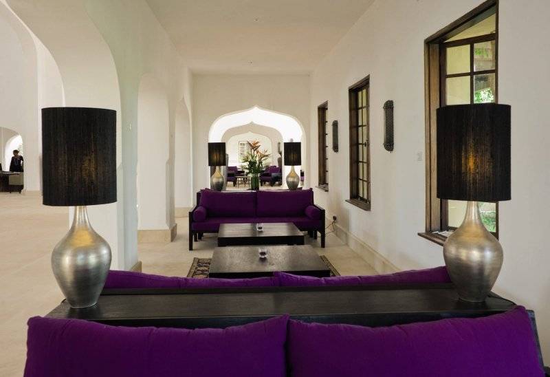 Loungebereich des Swahili Beach Resorts mit lila Sofas, schwarzen Tischen und silbernen Lampen.