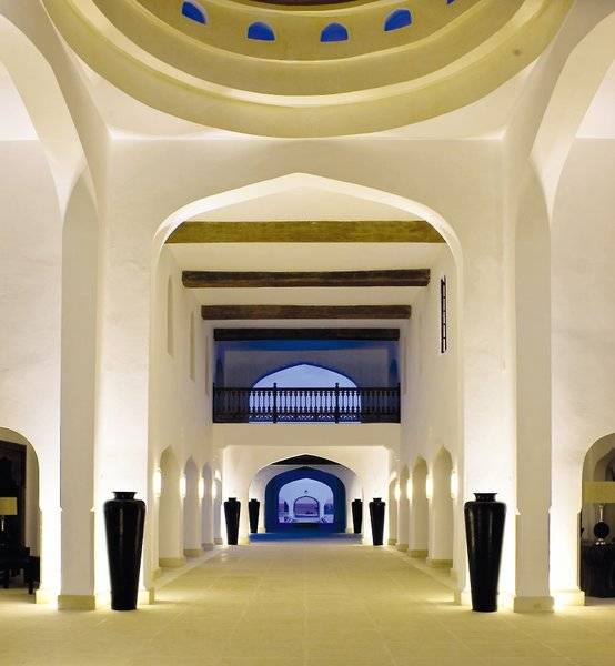 Aufnahme des hellen, offenen Lobbybereichs des Swahili Beach Resorts mit schwarzen Vasen und blauem Licht.