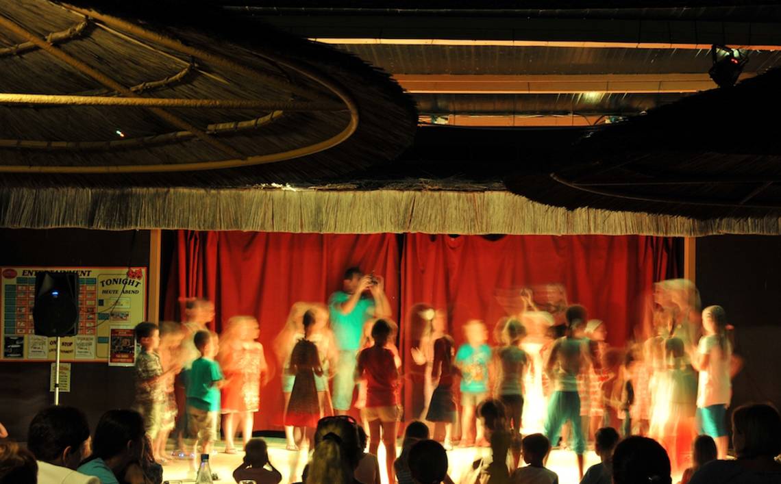 Kinderaufführung im Adams Beach Hotel mit rotem Vorhang im Hintergrund.