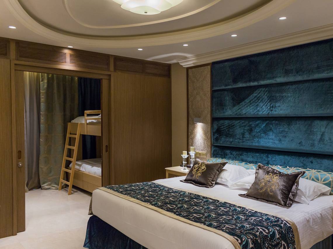 Schlafzimmer im Adams Beach Hotel mit einem Doppelbett und einem Etagenbett.