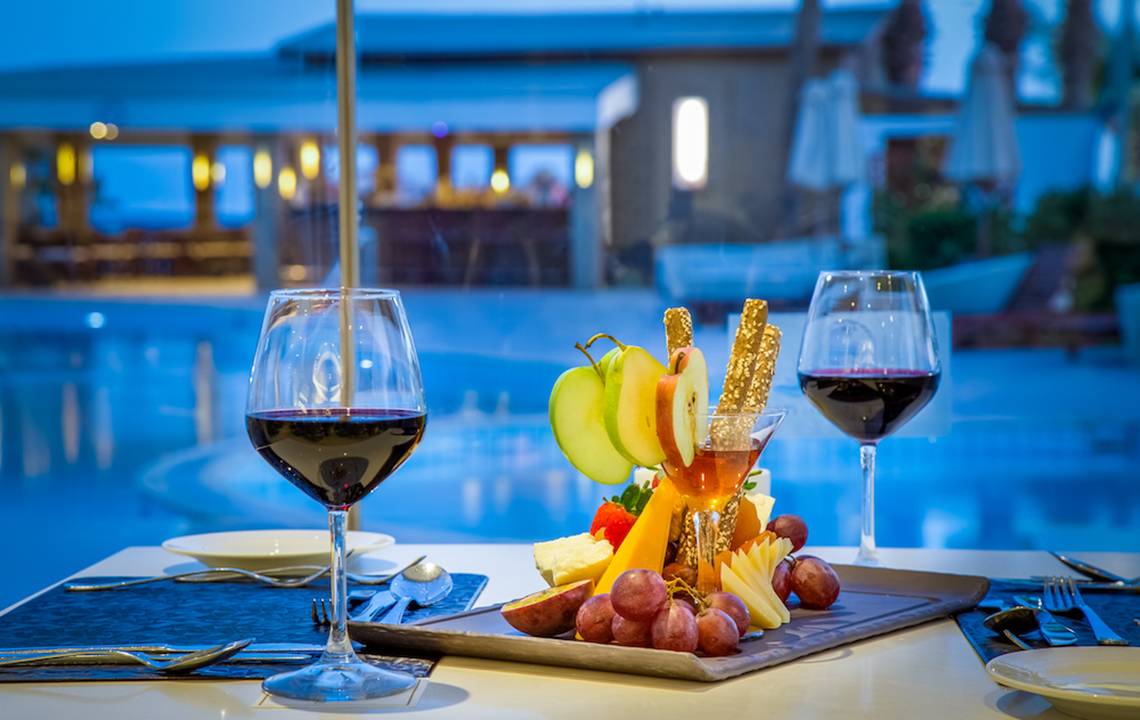 Adams Beach Hotel: Obstplatte mit Wein auf dem Tisch am Pool.