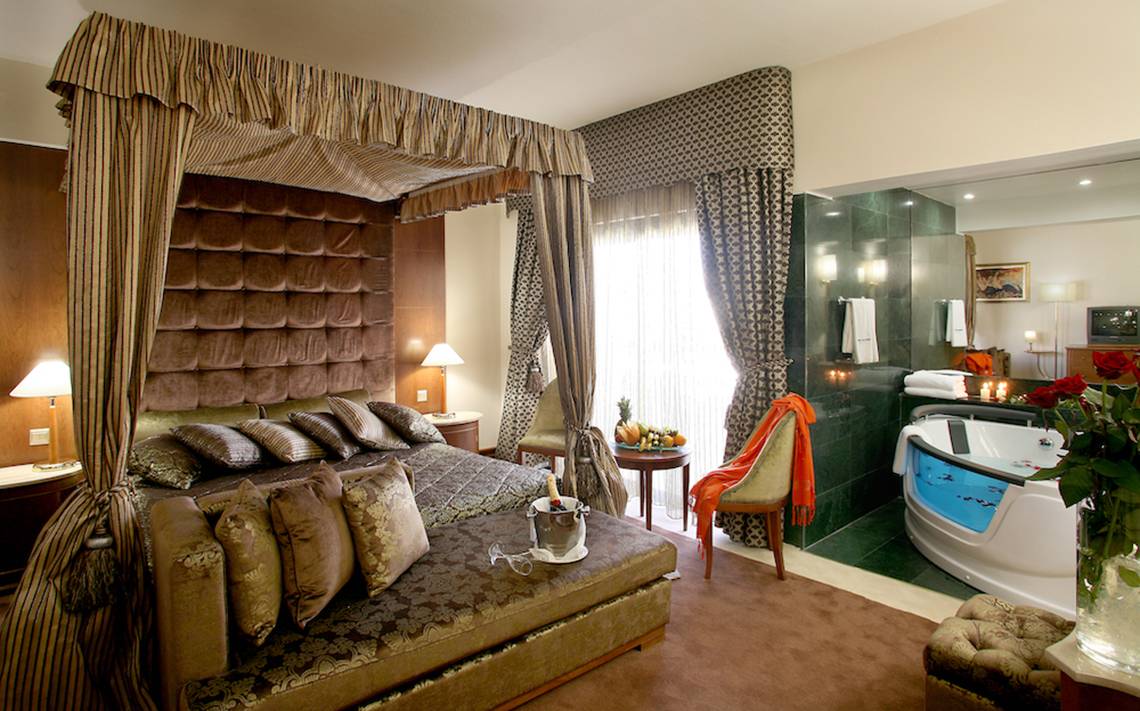 Schlafzimmer im Adams Beach Hotel mit Himmelbett, Badewanne und Dekor