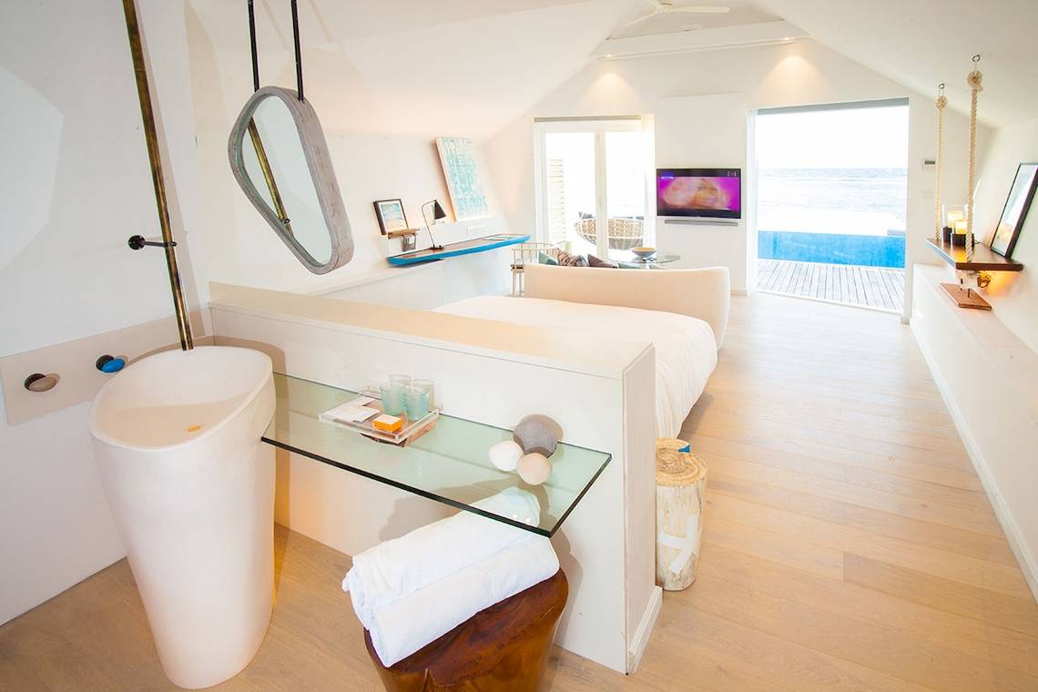 Luxuriöses Badezimmer im LUX South Ari Atoll Hotel mit offenem Fenster und Meerblick.